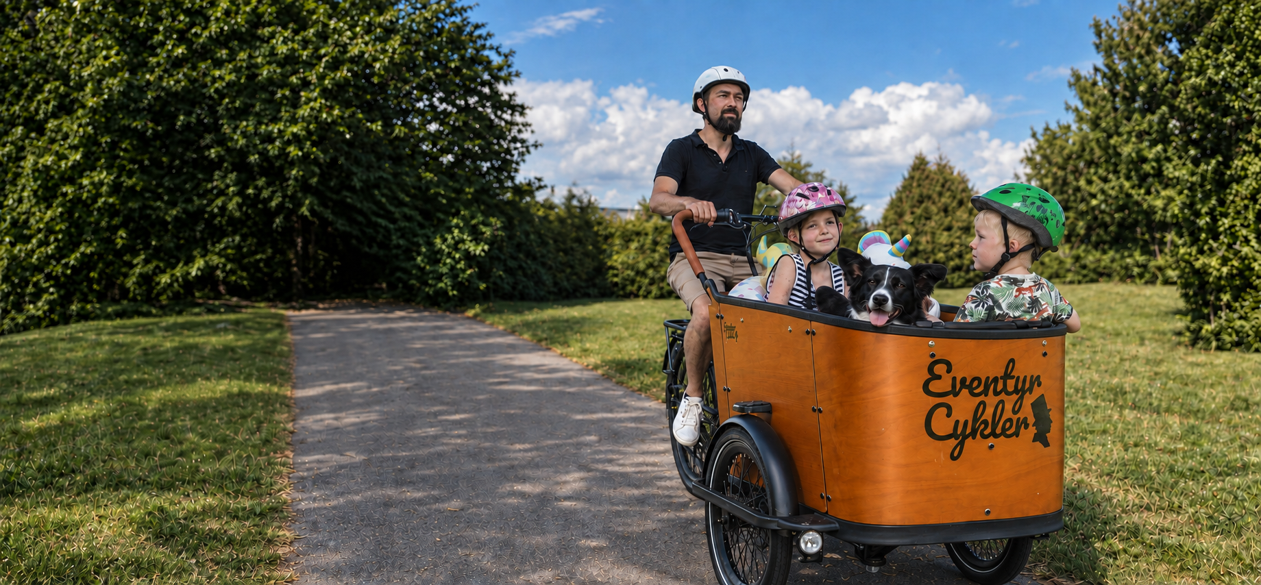 Familie med to børn og en hund på tur i en orange EventyrCykler ladcykel